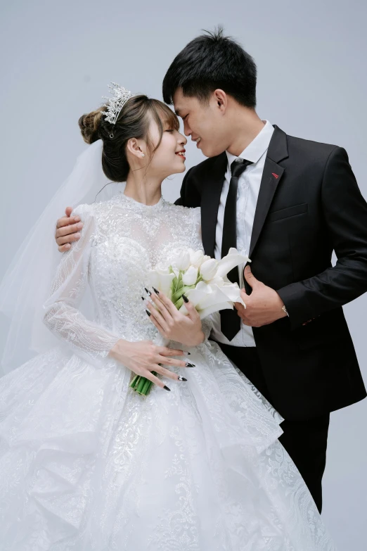 two people kissing in front of grey background