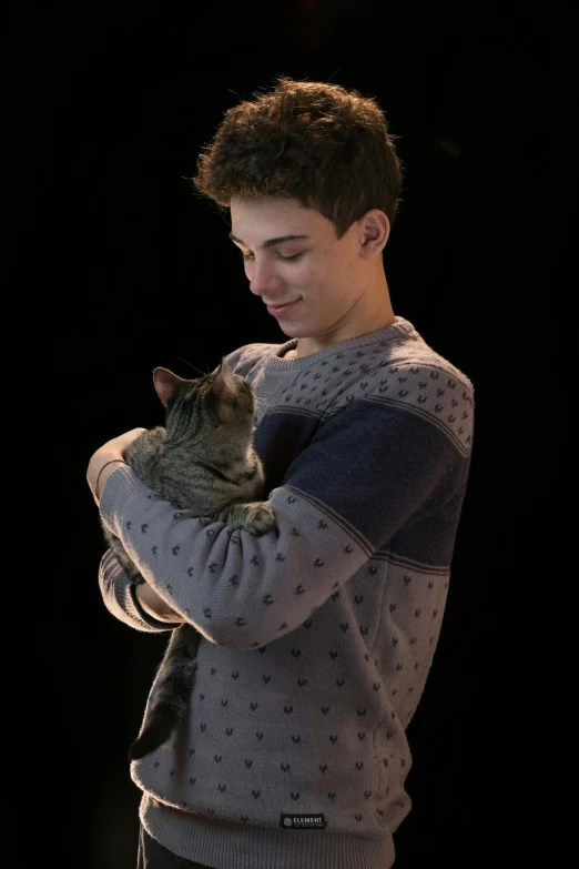 man holding up a cat in front of his face