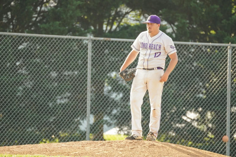 a pitcher at a baseball game stands on top of a mound