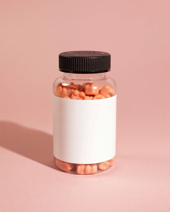 a pill bottle filled with pills sitting on top of a pink surface