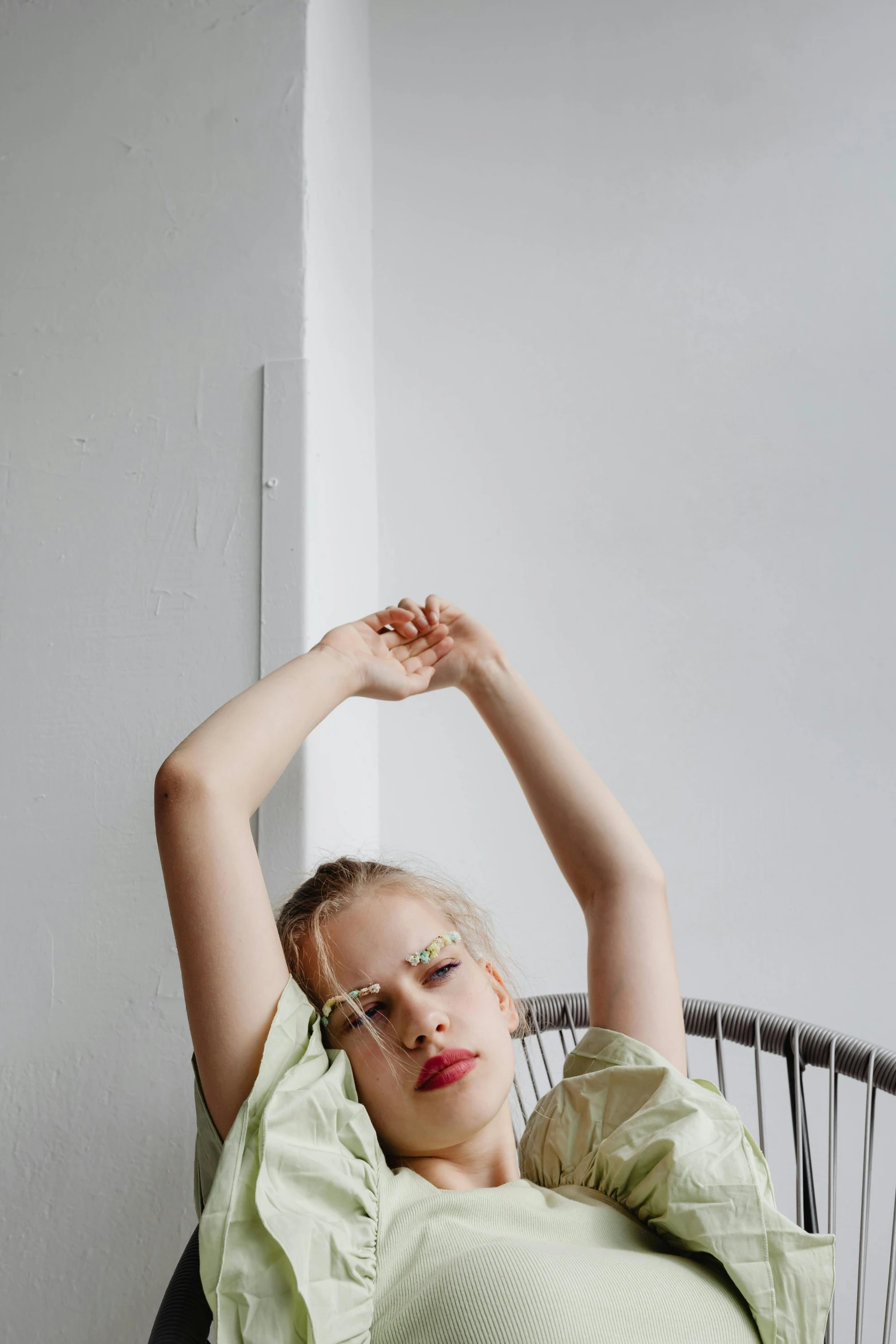 a woman is resting on a chair with her hand above her head