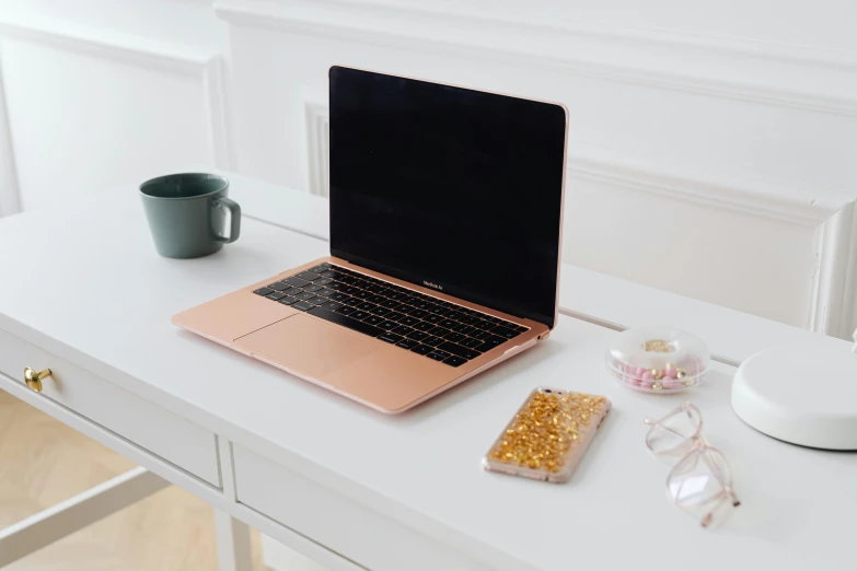 a laptop on a desk next to a cup and other items