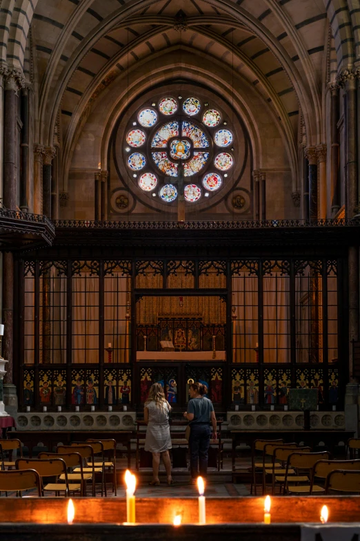 candle lit candles inside an old building that has an organ in it