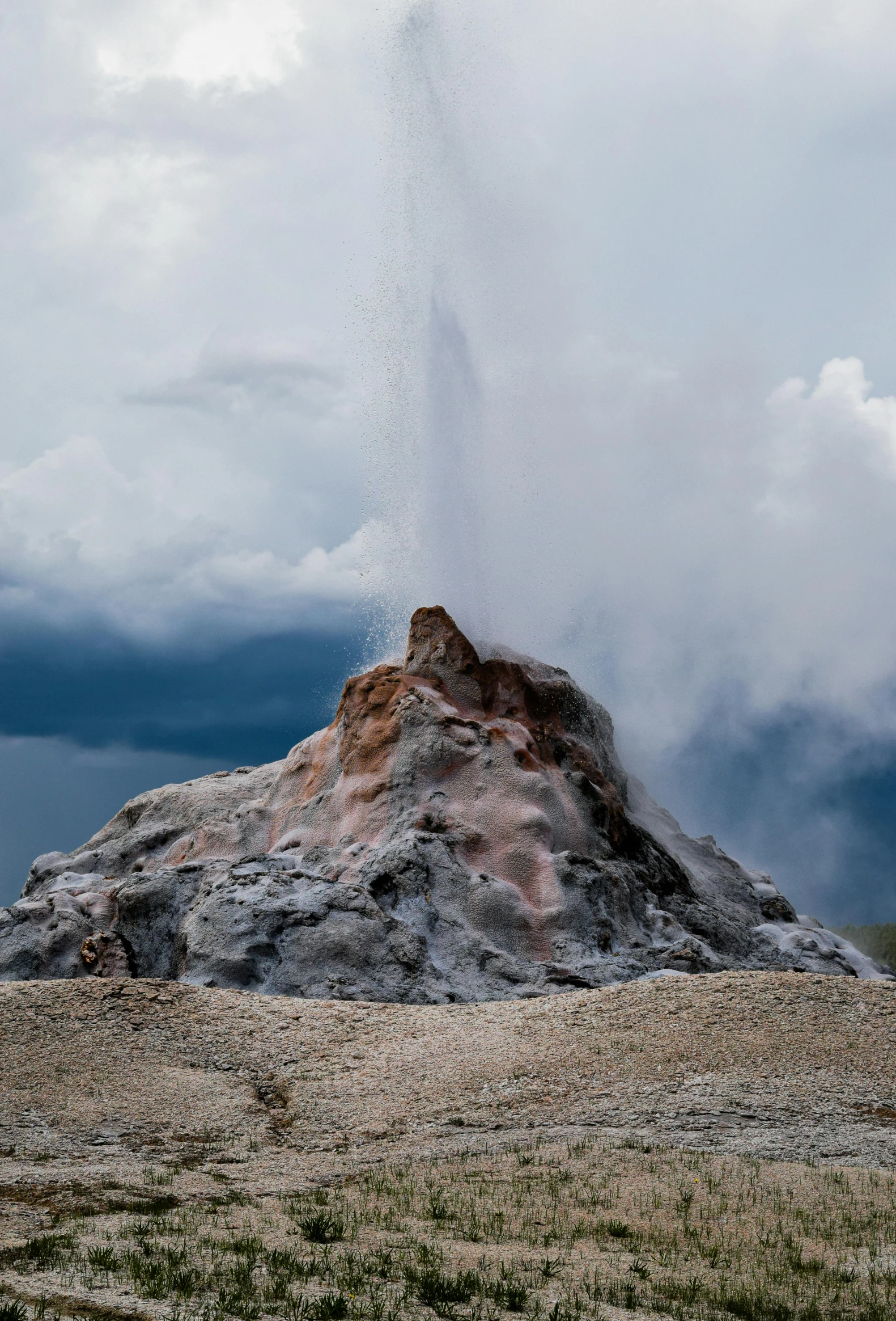 a volcano spewing water out of the top of a hill