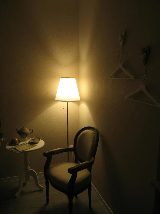 a chair with a lamp and table in a dark room