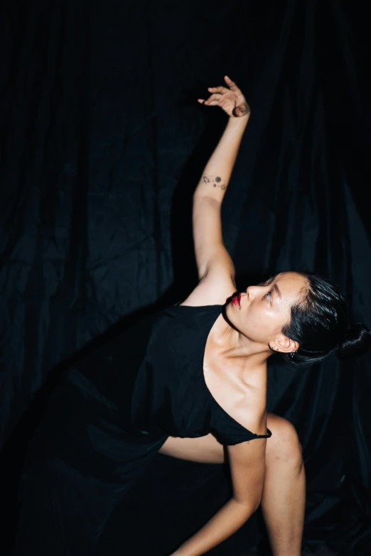 woman in black dress dancing on black cloth