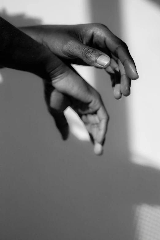 a woman's hands resting on the wall with sunlight coming in