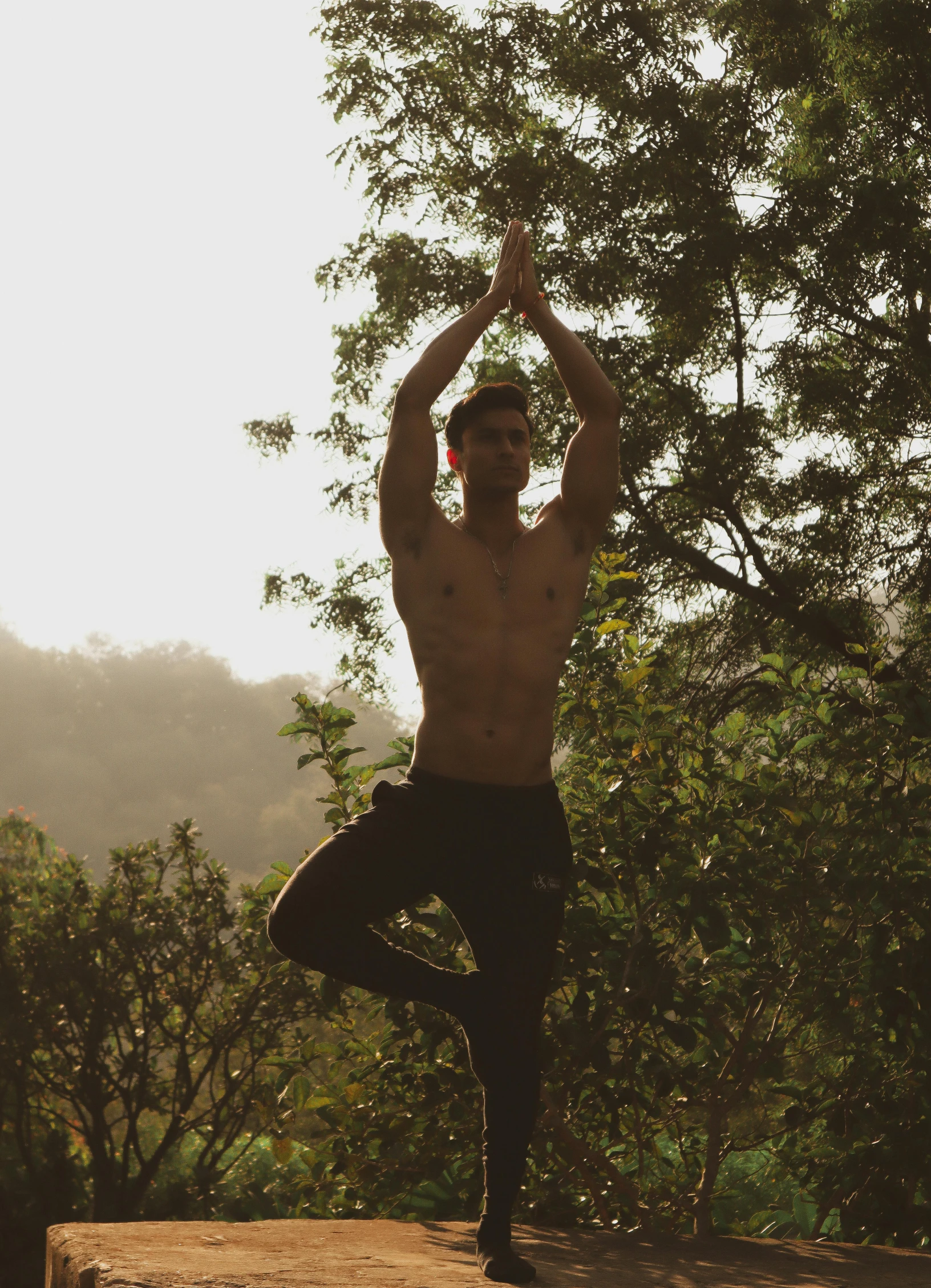 there is a man with  doing yoga outside