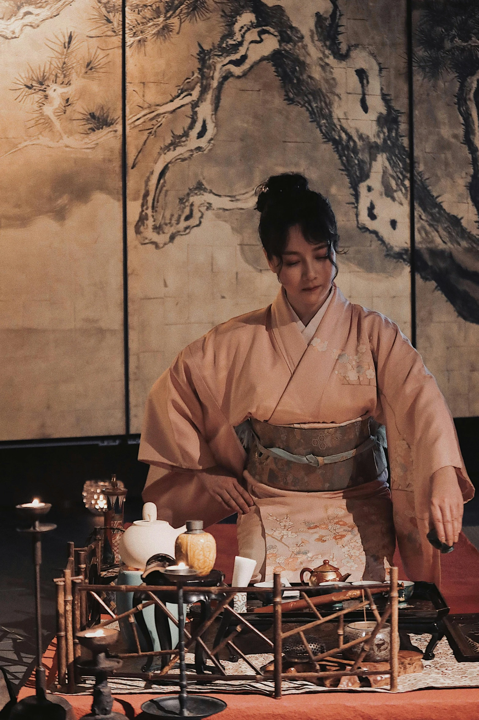 an asian woman in a kimono standing next to a table