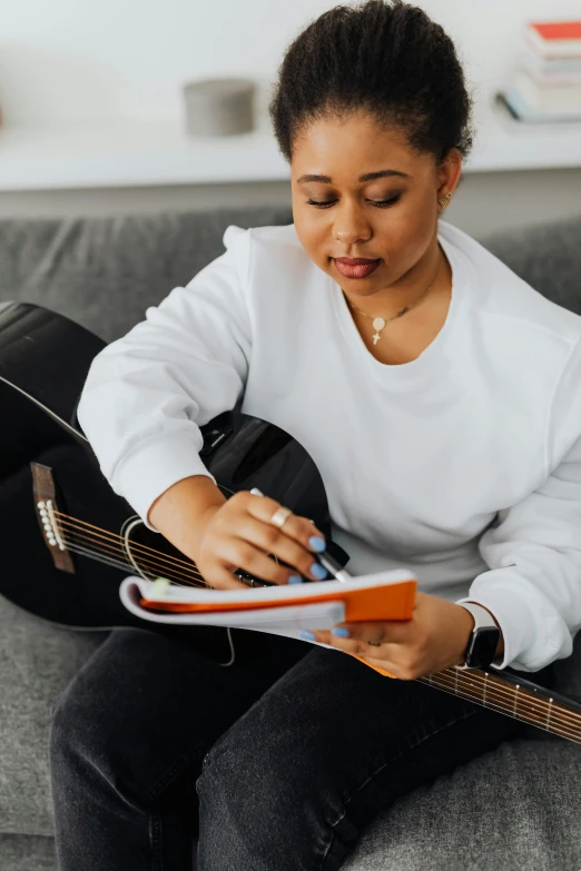 a woman sitting on a couch playing an ukulele