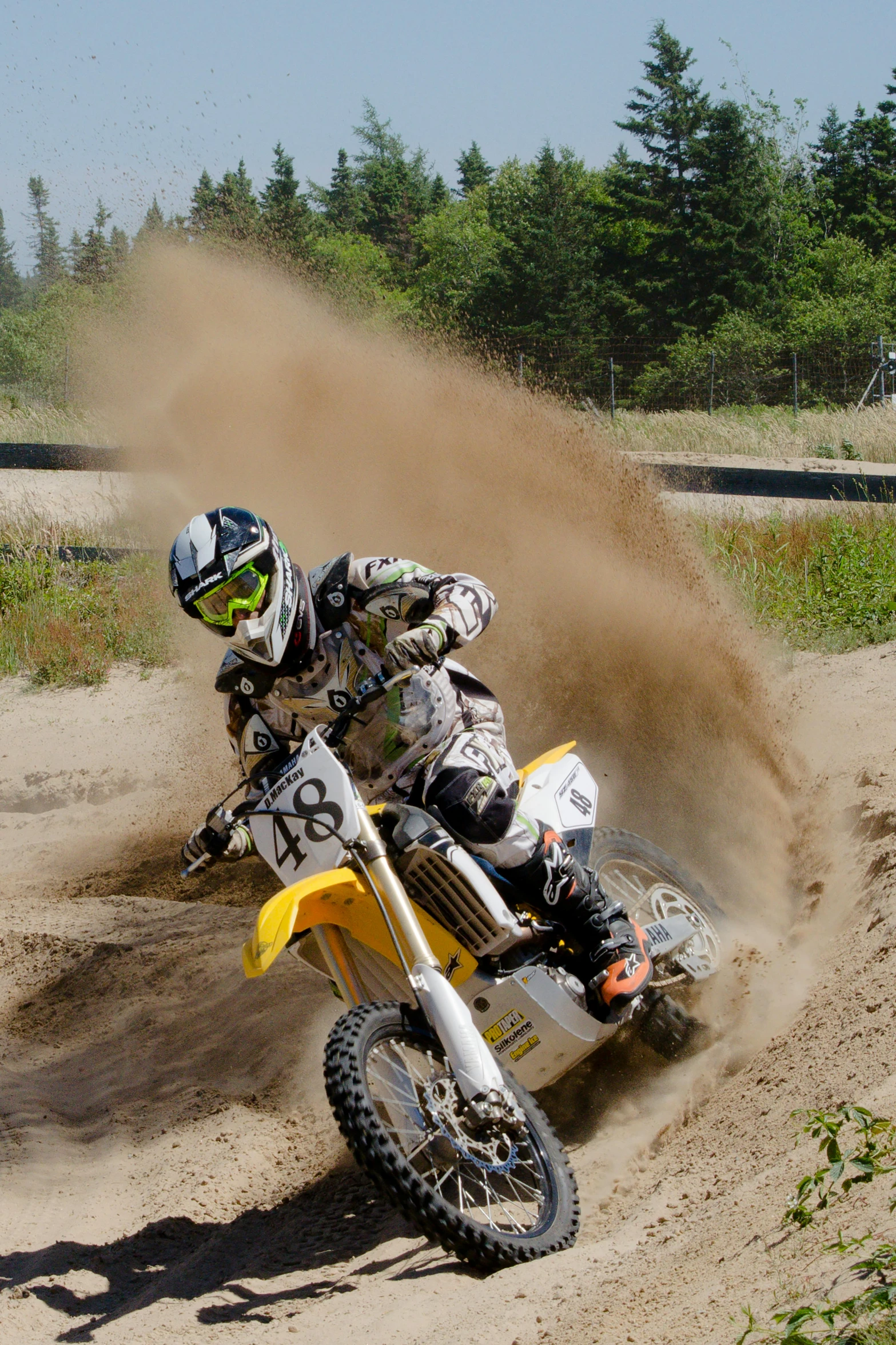 a dirt bike rider riding on the muddy ground