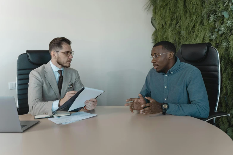 two people sitting at a table having an intersec meeting