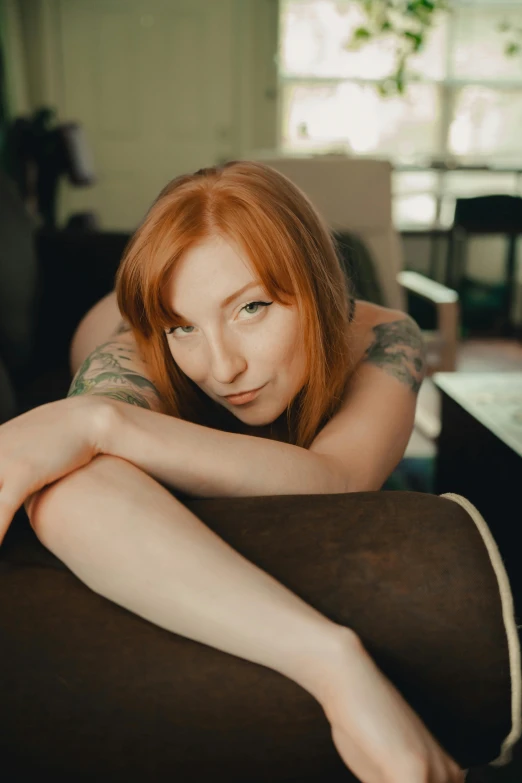 a girl poses for a picture on her couch