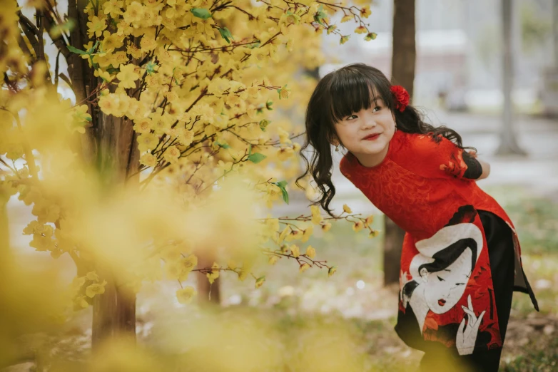 a young lady standing in front of a tree