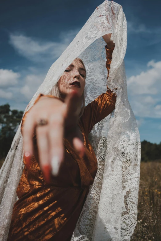 a woman wearing a golden dress and a white shawl