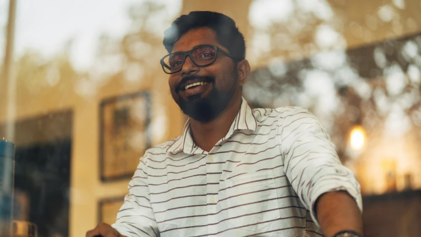 the man with glasses is smiling while holding a tray