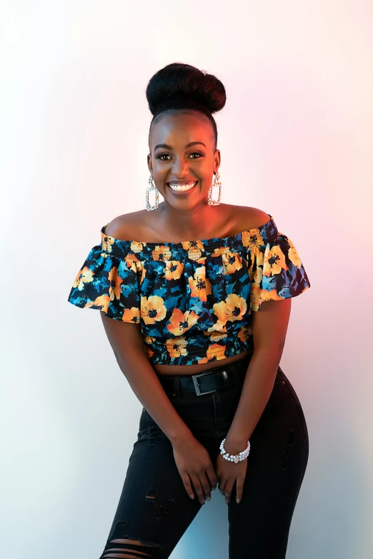 a black woman sitting on a stool smiling