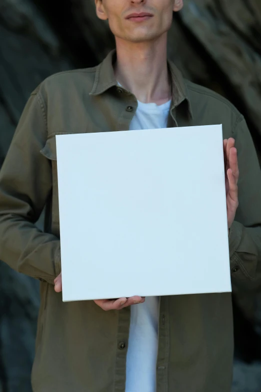 the man is holding a blank white paper in his hands