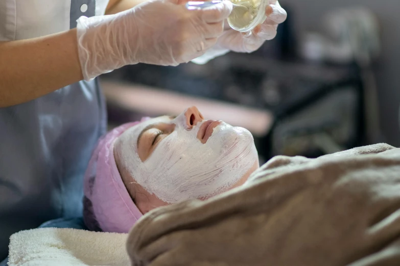 a person is receiving facial care from a woman