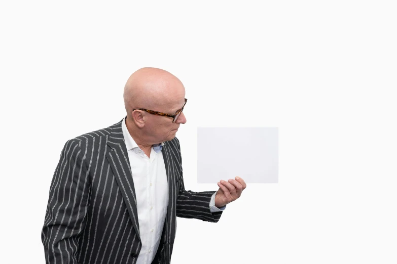 a man holding up a sheet of paper against a white background