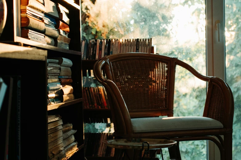 wicker and wicker chair sitting in front of a window filled with books