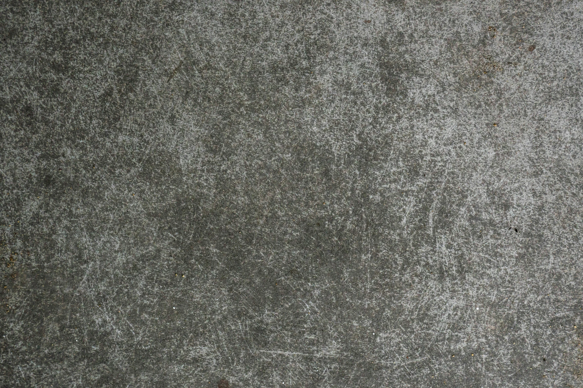 a street sign in front of a dirty cement surface