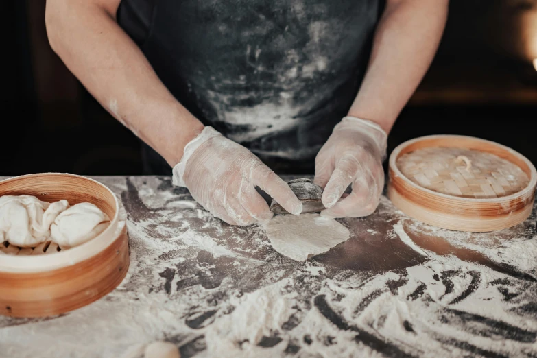 a person in a cooking costume is spreading ingredients on a table