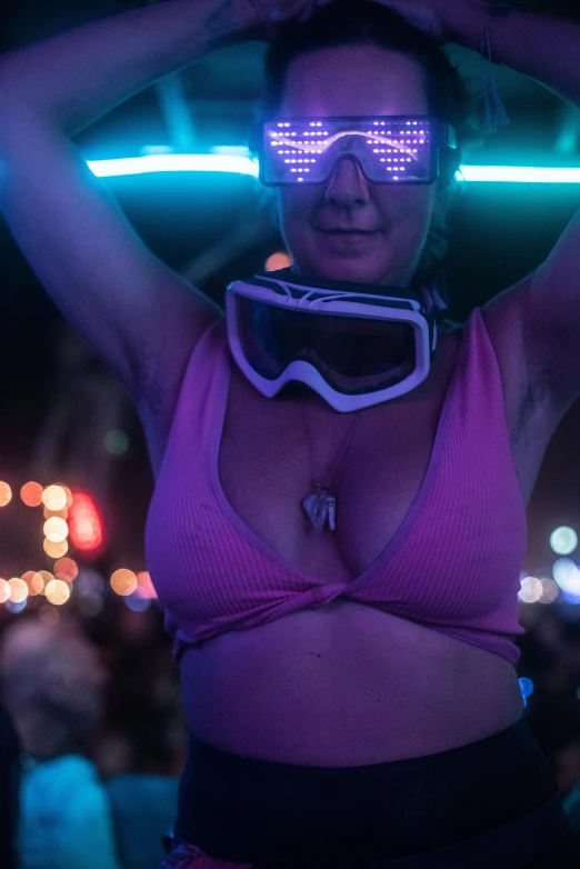 a woman with goggles on standing in front of the crowd