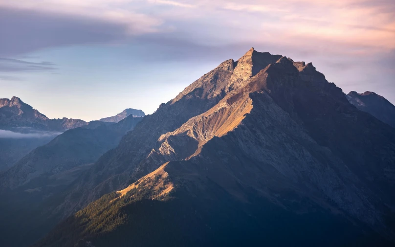 the mountains and trees are silhouetted in sunlight