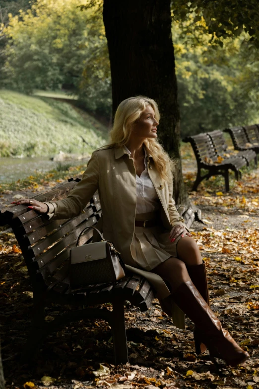 a woman sitting on a bench next to trees