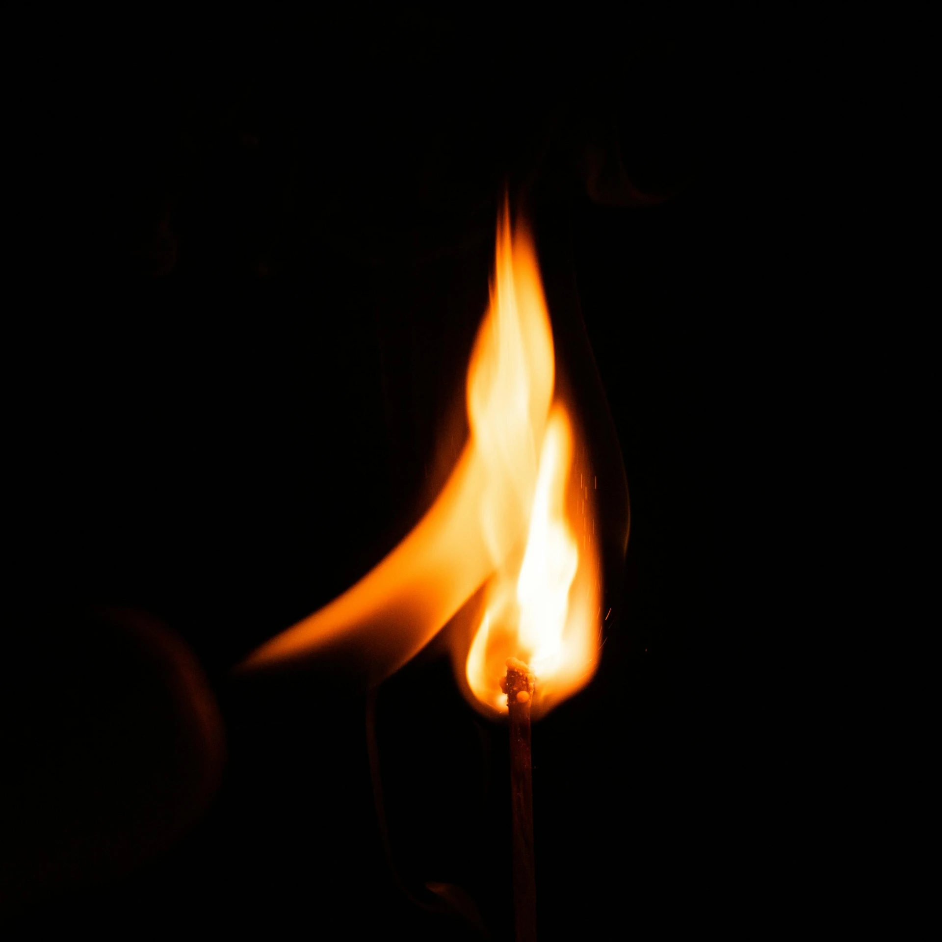 a person holding up a match lite in the dark