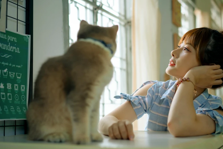 a woman sitting at a table with her cat