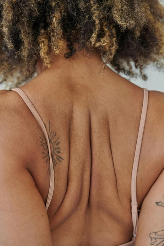 the back of a woman's body wearing a  top