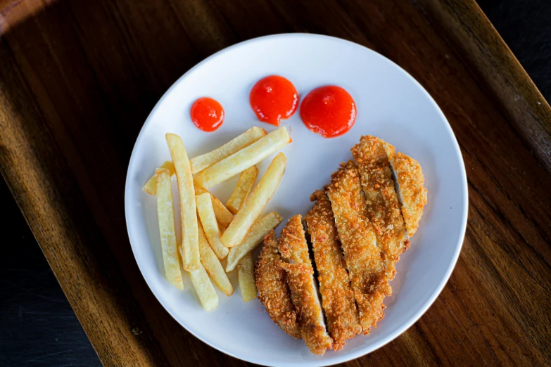 the plate contains a sandwich, french fries and cherry tomatoes