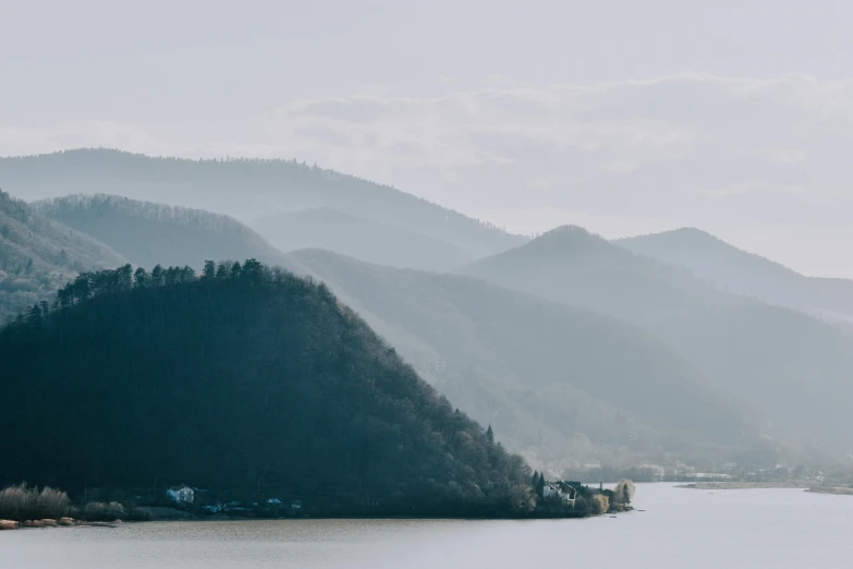 the mountain is behind some mountains near a body of water