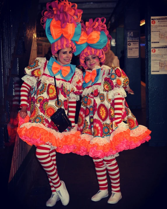 two children in clown costumes standing together