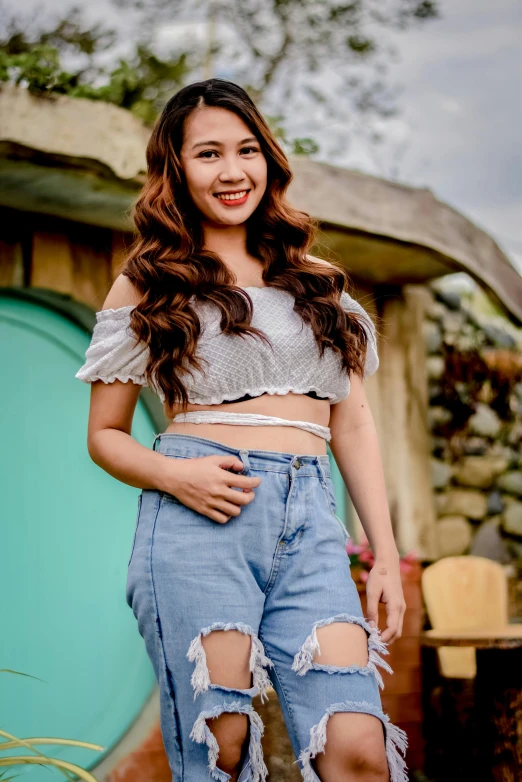 a woman in high rise jeans stands near a door