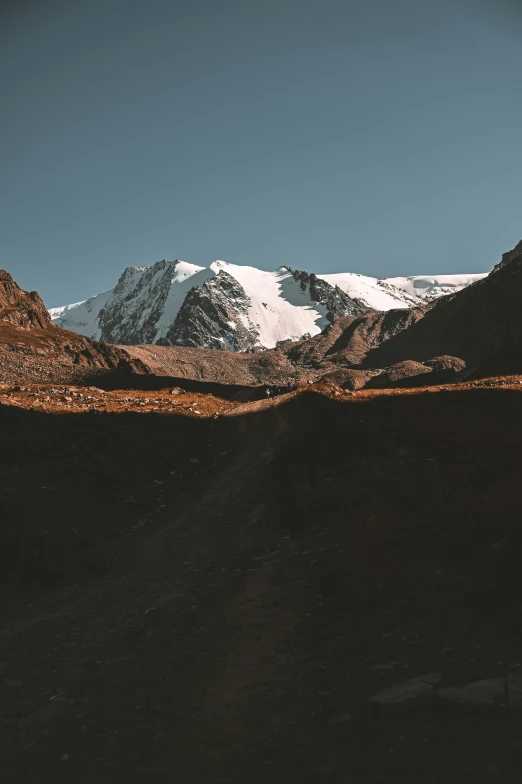 snow - covered mountain ridge with low sun in the background