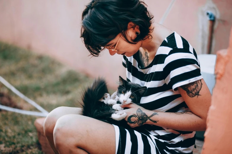 a woman is playing with her cat outside