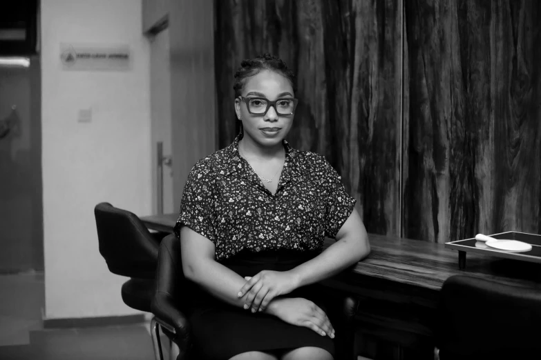 a woman in glasses sitting on a chair