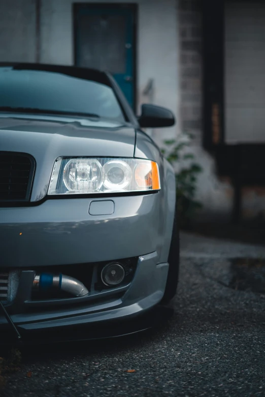 front view of a gray sedan parked on a side walk