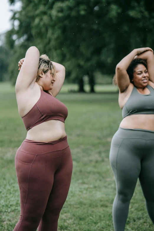 two women standing next to each other in the park