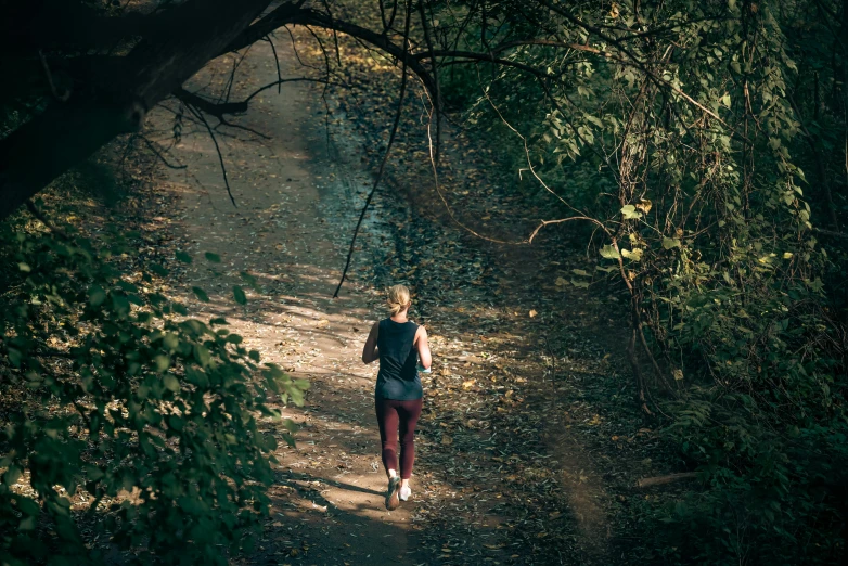 there is a woman that is walking down the trail