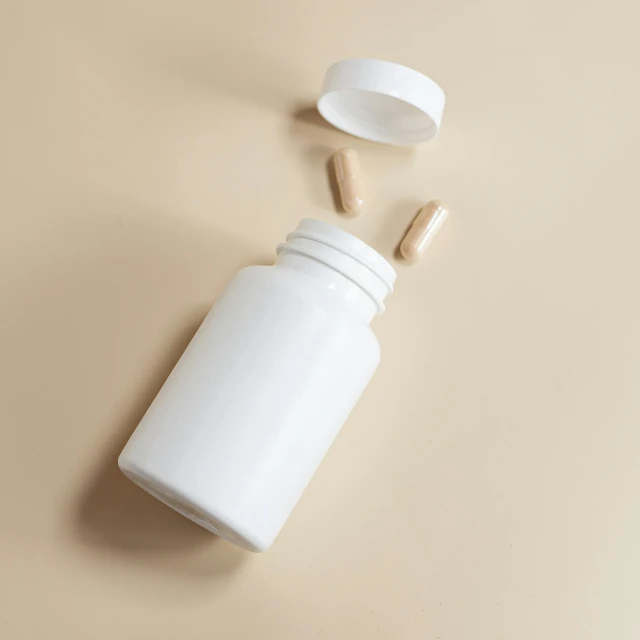 a bottle of pills and white glass caps