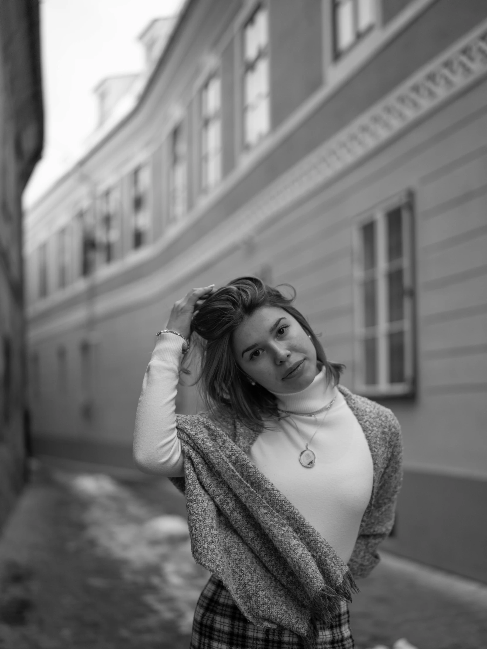 a young woman in checkered pants is posing for a black and white po