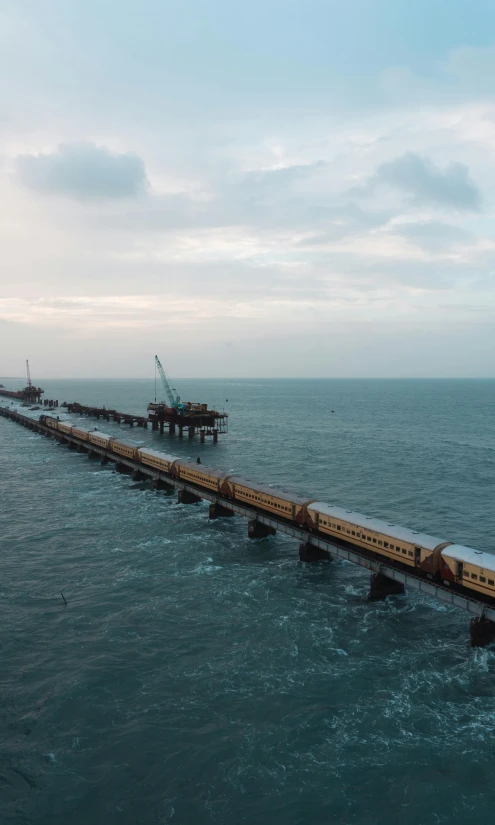 a train going over the water to go under a pier