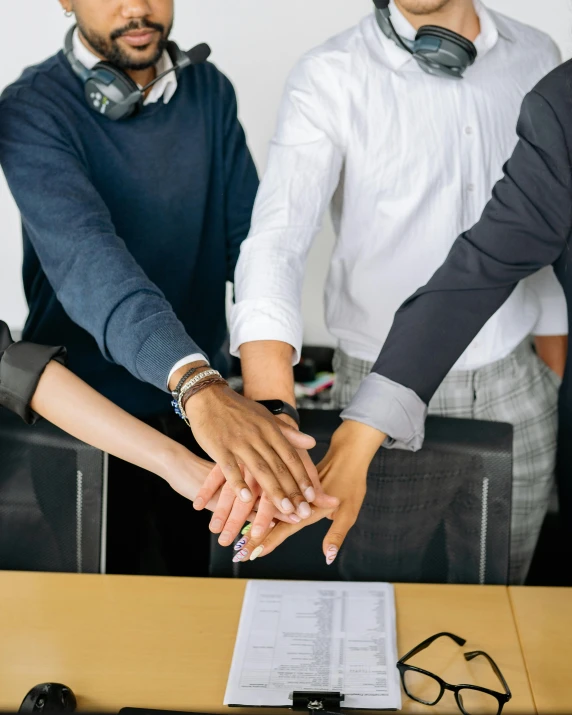 a group of people shaking hands in front of a desk