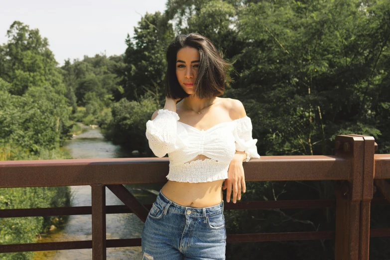 a woman is leaning on a fence looking over the top