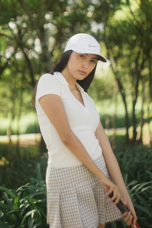 a young woman in a hat holding onto a tennis racket