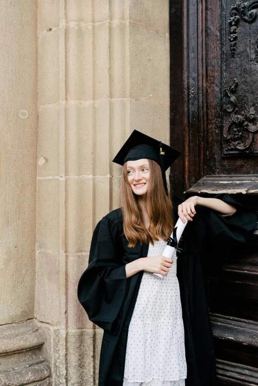 young lady standing outside of an old building at graduation